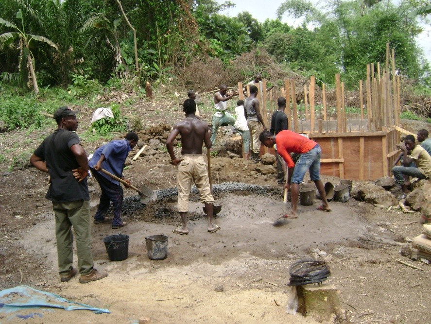 Community members building a concrete water storage tank